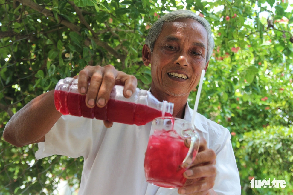 Ông Nguyễn Văn Vũ - ấp Giồng Lãnh 1, xã Tăng Hòa, huyện Gò Công Đông, tỉnh Tiền Giang - rót ly nước siro do mình làm mời khách - Ảnh: MẬU TRƯỜNG