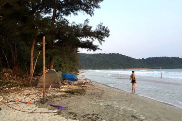 Một nhóm bạn cắm lều trên bãi biển, xung quanh cây gãy ngổn ngang và đầy rác - Ảnh: THÁI ANH