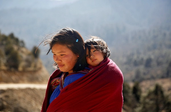 Hình ảnh một phụ nữ địu con trên lưng ở Bhutan. Hình ảnh một phụ nữ địu con trên lưng ở Bhutan.