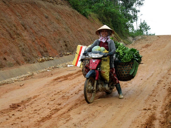 Một phụ nữ dùng xe máy chuyển lâm sản về xuôi (bao chứa dâu da đặt phía trước) - Ảnh: MINH KỲ Một phụ nữ dùng xe máy chuyển lâm sản về xuôi (bao chứa dâu da đặt phía trước) - Ảnh: MINH KỲ