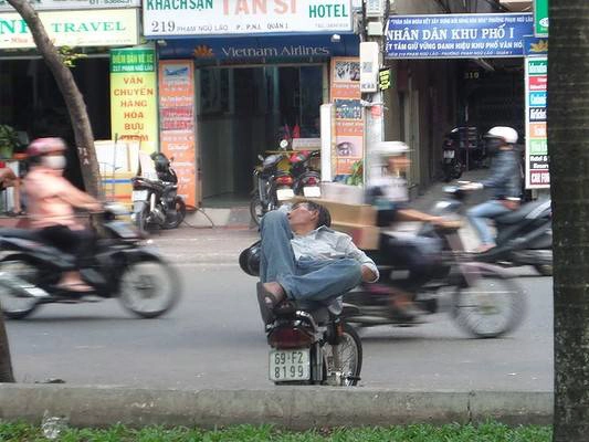 Các cư dân của thành phố Hồ Chí Minh dường như có một khả năng đặc biệt để có một giấc ngủ ngắn bất cứ nơi nào, bất kể những gì đang xảy ra xung quanh họ. Người đàn ông này không biết gì về xe máy whizzing qua trong khi ông là sự cân trên chiếc xe đạp của mình để ngủ trên đường Phạm Ngũ Lão, một con đường chính ở trung tâm của thành phố. Ảnh: Damien ngày