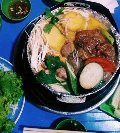 Nầm bò nướng Gầm Cầu: Phố Gầm Cầu chạy dọc chân cầu Long Biên từ Trần Nhật Duật đến đoạn cắt Phùng Hưng - Hàng Cót - Hàng Lược. Thực khách đi ngang khó có thể cầm lòng trước mùi đồ nướng hấp dẫn tỏa ra từ dãy hàng quán dọc con phố này. Đều là hàng vỉa hè, các quán nướng ở đây có chỗ ngồi khá chật hẹp, khách ngồi ăn thi thoảng còn nghe tiếng tàu hỏa rầm rập chạy qua. Thực khách sẽ tự nướng đồ ăn trên bếp cồn với một chiếc chảo bé bọc giấy bạc. Cho ít bơ vào chảo, sau đó xếp thịt bò, nầm bò, lòng, dạ dày, rau củ lên trên, khách nướng đến đâu ăn đến đấy. Món ăn sẽ thêm phần phong phú nếu dùng kèm bánh mì nướng mật ong và nước ngô. Quán ngay đầu phố sát với Hàng Lược được nhiều người yêu thích nhất, chi phí khoảng 100.000 đồng/người. Ảnh: Phiêu Linh