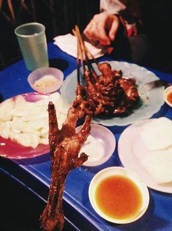 Chân gà nướng Lý Văn Phúc: Từ Nguyễn Thái Học rẽ vào phố Lý Văn Phúc, dù hương thơm của chân gà nướng rất hấp dẫn nhưng bạn hãy bỏ qua các hàng đầu tiên, đi đến hàng được nhiều người gợi ý nhất cho món ăn này ở cuối phố, phía tay phải. Chân gà, cánh gà, dạ dày, sườn nướng được tẩm ướp đậm đà, ăn kèm với bánh mì mật ong, dưa chuột muối, nộm rau muống chua ngọt. Tương ớt cay cay khiến các món ăn càng thêm hấp dẫn. Một cuộc hẹn ở đây sẽ tốn khoảng 150.000 đồng/2 người. Ảnh: Phiêu Linh