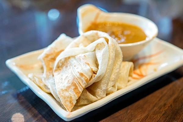 <strong>Roti canai:</strong> Đây là món ăn sáng điển hình của Malaysia, có nguồn gốc từ Ấn Độ. Tuy nhiên, bạn có thể thưởng thức vào bất cứ thời điểm nào trong ngày. Bột mì, trứng và ghee (bơ đun chảy và bỏ bớt nước) được trộn đều, tán mỏng trên chảo nướng và sau đó gập lại. Món này rất ngon khi ăn nóng, với ruột mềm và vỏ giòn. Roti canai thường được dùng kèm cà ri. Ảnh: Michael Shum/Flickr. <strong>Roti canai:</strong> Đây là món ăn sáng điển hình của Malaysia, có nguồn gốc từ Ấn Độ. Tuy nhiên, bạn có thể thưởng thức vào bất cứ thời điểm nào trong ngày. Bột mì, trứng và ghee (bơ đun chảy và bỏ bớt nước) được trộn đều, tán mỏng trên chảo nướng và sau đó gập lại. Món này rất ngon khi ăn nóng, với ruột mềm và vỏ giòn. Roti canai thường được dùng kèm cà ri. Ảnh: Michael Shum/Flickr.
