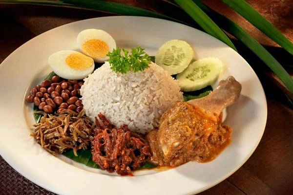 Nasi lemak: Đây được coi là món ăn biểu trưng của Malaysia với nguyên liệu phong phú và cách trình bày đẹp mắt. Cơm nấu cốt dừa được cho lên lá chuối xanh, rưới sốt sambal cay, cá trống khô, lạc rang, dưa chuột, trứng (luộc hoặc ốp la), đôi thi có thêm thịt gà hoặc hải sản. Ảnh: Touristic360. Nasi lemak: Đây được coi là món ăn biểu trưng của Malaysia với nguyên liệu phong phú và cách trình bày đẹp mắt. Cơm nấu cốt dừa được cho lên lá chuối xanh, rưới sốt sambal cay, cá trống khô, lạc rang, dưa chuột, trứng (luộc hoặc ốp la), đôi thi có thêm thịt gà hoặc hải sản. Ảnh: Touristic360.