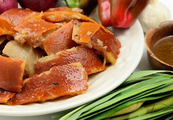 Lechon: Đây là món ăn quen thuộc trong các bữa tiệc hay dịp trọng đại. Lợn được nướng nguyên con trên than hoa cho tới khi có lớp da vàng ruộm, phần thịt mềm thơm ngọt. Thịt lợn được chặt miếng và chấm cùng sốt gan. Ảnh: Travelerknow.