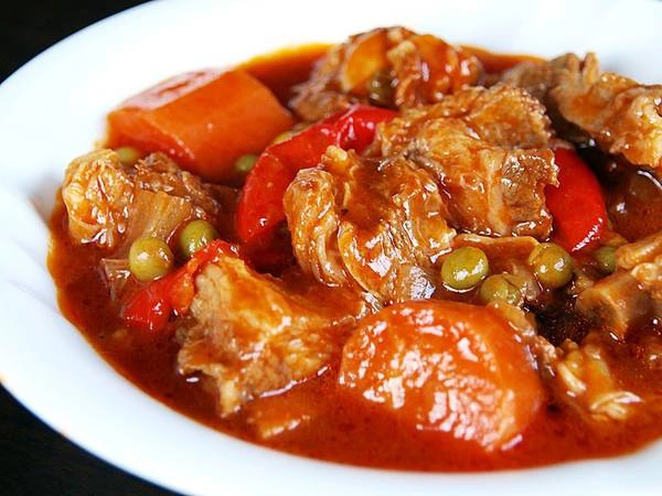 Kaldereta: Món hầm này trước kia được làm từ thịt dê, nhưng giờ có thể sử dụng thịt bò hoặc thịt lợn thay thế. Thịt được thái miếng to, đun nhừ với khoai tây, cà chua và thêm sốt gan, tạo hương vị đậm đà, thơm ngậy. Ảnh: Recipeshubs. 