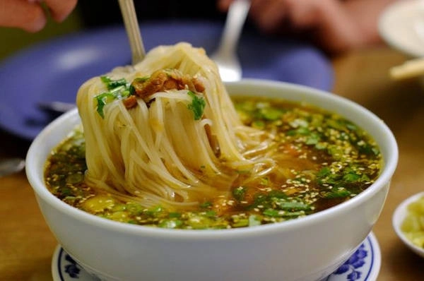 Mì người Shan: Sợi mì dẹt và mảnh được chan nước dùng cay, cho thêm thịt lợn hoặc thịt gà, vừng rang và chút dầu tỏi. Món này được ăn cùng rau củ muối. Ảnh: Flavorverse. Mì người Shan: Sợi mì dẹt và mảnh được chan nước dùng cay, cho thêm thịt lợn hoặc thịt gà, vừng rang và chút dầu tỏi. Món này được ăn cùng rau củ muối. Ảnh: Flavorverse.