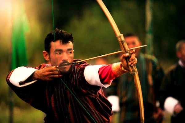6. Tình yêu cuồng nhiệt với môn bắn cung: Dường như trên đất nước Bhutan lúc nào cũng có một cuộc thi đấu bắn cung diễn ra. Trong chuyến du lịch 17 ngày tại Bhutan của Will Hatton, anh đã chứng kiến cuộc tranh tài giữa 2 ngôi làng ở độ cao 4.200 m. Cung thủ mặc váy truyền thống, nhắm vào bia ngắm cách 140 m có kích thước bằng một chiếc đĩa. Dân làng đi bộ gần 2 ngày qua các ngọn núi để đến khu vực thi đấu. Hễ một cung thủ bắn xong, cả 2 đội đều nhảy và hát tựa như những chiến binh Bhutan cổ xưa. Ảnh: Norbuling. 6. Tình yêu cuồng nhiệt với môn bắn cung: Dường như trên đất nước Bhutan lúc nào cũng có một cuộc thi đấu bắn cung diễn ra. Trong chuyến du lịch 17 ngày tại Bhutan của Will Hatton, anh đã chứng kiến cuộc tranh tài giữa 2 ngôi làng ở độ cao 4.200 m. Cung thủ mặc váy truyền thống, nhắm vào bia ngắm cách 140 m có kích thước bằng một chiếc đĩa. Dân làng đi bộ gần 2 ngày qua các ngọn núi để đến khu vực thi đấu. Hễ một cung thủ bắn xong, cả 2 đội đều nhảy và hát tựa như những chiến binh Bhutan cổ xưa. Ảnh: Norbuling.
