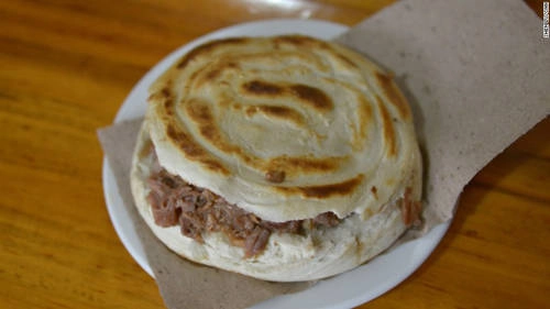 Bánh burger Tây An (roujiamo) Giống một chiếc bánh mì kẹp (burger) nhưng roujiamo có lịch sử lâu đời hơn. Bánh chỉ có hai nguyên liệu chính là bánh mì nướng và thịt om. Một chiếc roujiamo được nướng bằng bếp truyền thống không phải bếp điện. Thịt ăn cùng thường nửa nạc nửa mỡ đã được om trong nhiều giờ, nghiền vụn và nhồi vào bánh mì. Bánh burger Tây An (roujiamo) Giống một chiếc bánh mì kẹp (burger) nhưng roujiamo có lịch sử lâu đời hơn. Bánh chỉ có hai nguyên liệu chính là bánh mì nướng và thịt om. Một chiếc roujiamo được nướng bằng bếp truyền thống không phải bếp điện. Thịt ăn cùng thường nửa nạc nửa mỡ đã được om trong nhiều giờ, nghiền vụn và nhồi vào bánh mì.