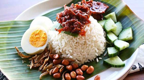 Nasi Lemak (cơm dừa truyền thống) Món cơm dừa là đồ ăn truyền thống của Malaysia, gồm có cơm trắng nấu nước cốt dừa phục vụ trên lá chuối (hoặc bát đĩa có hình lá chuối) cùng cá cơm chiên, lạc rang, dưa chuột và trứng luộc thái lát. Ngoài ra có thể ăn cùng mực, thịt gà, sò, thịt bò rendang và rau muối. Nasi Lemak (cơm dừa truyền thống) Món cơm dừa là đồ ăn truyền thống của Malaysia, gồm có cơm trắng nấu nước cốt dừa phục vụ trên lá chuối (hoặc bát đĩa có hình lá chuối) cùng cá cơm chiên, lạc rang, dưa chuột và trứng luộc thái lát. Ngoài ra có thể ăn cùng mực, thịt gà, sò, thịt bò rendang và rau muối.