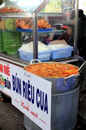 <strong>Các món nước ấm nóng như bún riêu, bánh canh, hủ tiếu:  </strong>Càng về đêm, khí hậu Đà Lạt càng trong lành, mát lạnh. Vì vậy đa phần các món ăn ở Đà Lạt đều là những món ấm nóng, vị hơi nhạt, cay. Nếu bụng đang cồn cào và muốn tìm một món ăn chắc dạ, bạn có thể ghé vào dãy ẩm thực nằm ở lối vào bên trái chợ để thưởng thức bún riêu, bánh canh, hủ tiếu…