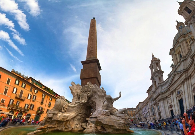 Quảng trường Navona  Navona được xây dựng trên tàn tích của rạp xiếc cổ hình bầu dục từ thời hoàng đế La Mã Domitian. Sau khi được cải tạo, quảng trường có thêm các tòa nhà bao quanh và nhiều đài phun nước phong cách baroque.  Ban ngày, không khí ở quảng trường luôn nhộn nhịp với nhiều hoạt động. Du khách nên đến đây vào buổi tối khi không đông đúc và chiêm ngưỡng những màn trình chiếu ánh sáng bắt mắt.