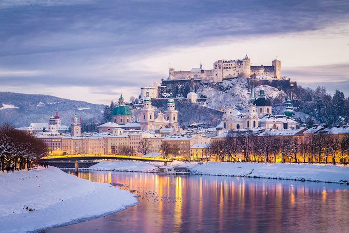 Salzburg, Áo  Nằm bên dòng Salzach chảy xiết, thành phố Salzburg hiện lên huyền ảo trong mùa đông với những mái vòm, ngọn tháp cổ kính, hay pháo đài hùng vĩ trên triền núi. Rất nhiều địa điểm tại Salzburg đã từng xuất hiện trong bộ phim kinh điển The Sound of Music (Giai điệu hạnh phúc), bạn có thể đi tour The Sound of Music Panorama để chiêm ngưỡng những khung cảnh tuyệt đẹp trong phim. Một địa chỉ ẩm thực đáng ghé thăm là nhà hàng Goldener Hirsch trên phố cổ Getreidegasse, phục vụ những món ăn truyền thống của Áo theo phong cách hiện đại. Ảnh: Travelling King.