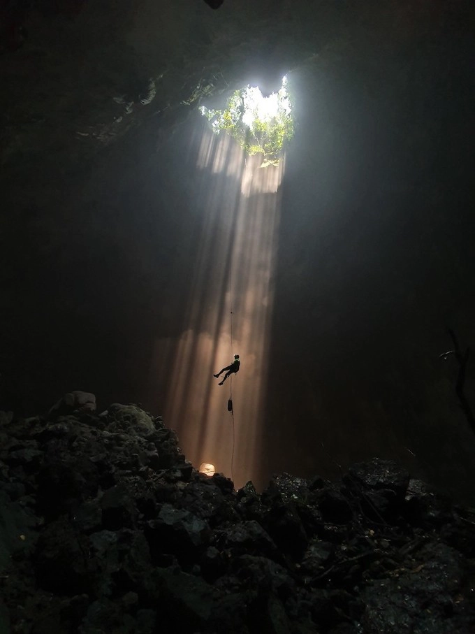 Trong ảnh là hang Loong Coong. Hang này nằm trên đỉnh hang Sơn Đoòng. Cách duy nhất để xuống hang là đu dây thẳng đứng hơn 80 m, sau đó leo ra khỏi hang cũng bằng cách đu dây.