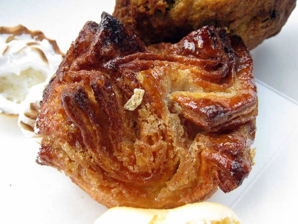 Kouign Amann có xuất xứ từ vùng Britanny, được làm bằng loại bột tương tự với bánh croissant: bột nhiều lớp với độ giòn đặc trưng. Kouign Amann sẽ dắt bạn tới thiên đường của bơ và caramen.