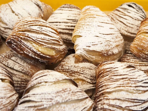 9. Sfogliatella: Chiếc bánh sfogliatella có hình dáng như đuôi tôm hùm, là một loại bánh nướng đầy hương vị đến từ vùng Campania của nước Ý. Sfogliatella có nghĩa là "lá mỏng", vì cấu trúc của bánh giống với lá xếp chồng lên nhau. 9. Sfogliatella: Chiếc bánh sfogliatella có hình dáng như đuôi tôm hùm, là một loại bánh nướng đầy hương vị đến từ vùng Campania của nước Ý. Sfogliatella có nghĩa là "lá mỏng", vì cấu trúc của bánh giống với lá xếp chồng lên nhau.