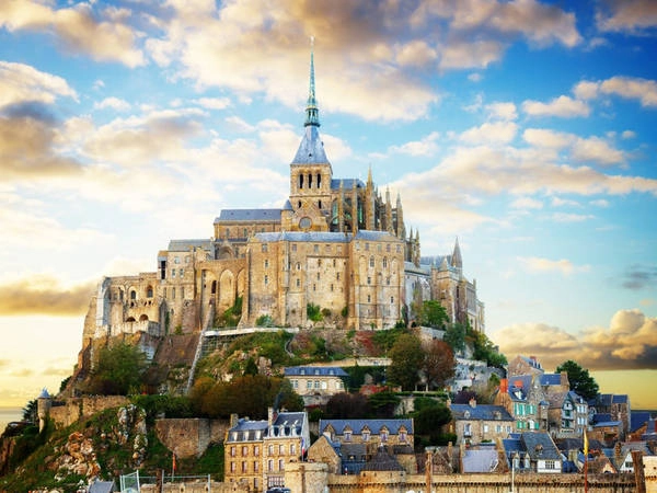 Tu viện Mont Saint-Michel, Pháp: Tu viện nằm giữa một ngôi làng nhỏ trên hòn đảo ngoài khơi bờ biển của vùng Normandy, Pháp. Lịch sử của tu viện bắt đầu từ năm 709, khi Aubert, Giám mục của Avranches, quyết định xây dựng một nhà thờ nhỏ trên đảo. Tới thế kỷ 12, một tu viện lớn đã được xây dựng tại đây. Ngày nay, du khách có thể ghé thăm hòn đảo, leo lên khu vực cao nhất và tận hưởng khung cảnh tuyệt vời cùng kiến trúc ngoạn mục nơi đây. Ảnh: Neirfy/Shutterstock.