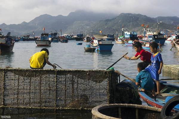 Những đứa trẻ địa phương đang được người lớn dạy về cách đánh cá bằng lồng. Như những làng chài khác ở Việt Nam, ngư nghiệp được duy trì theo kiểu cha truyền con nối truyền thống.