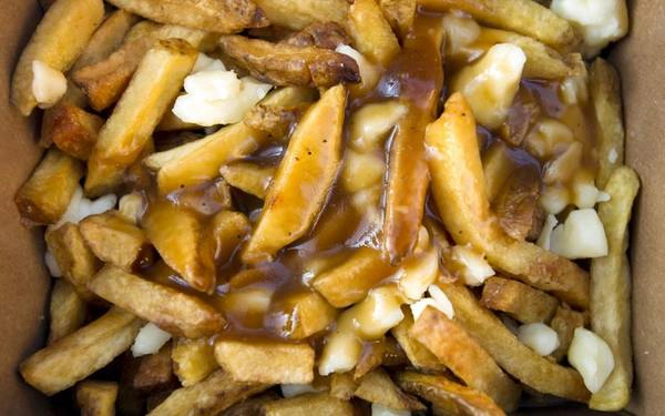 Poutine (Canada): Khoai tây chiên rưới nước thịt và thêm phô mai vừa rẻ, vừa ngon. Đây là món ăn được nhiều du khách yêu thích. Ảnh: Roughguides. Poutine (Canada): Khoai tây chiên rưới nước thịt và thêm phô mai vừa rẻ, vừa ngon. Đây là món ăn được nhiều du khách yêu thích. Ảnh: Roughguides.