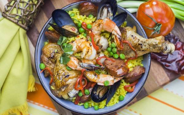 Paella (Tây Ban Nha): Paella có nguồn gốc từ Valencia, ban đầu chỉ là món giá rẻ, no bụng dành cho nông dân, gồm cơm, rau và thịt thỏ vụn. Ngày nay, Paella có thêm nhiều nguyên liệu phong thú, như xúc xích cay, hải sản. Ảnh: Roughguides. Paella (Tây Ban Nha): Paella có nguồn gốc từ Valencia, ban đầu chỉ là món giá rẻ, no bụng dành cho nông dân, gồm cơm, rau và thịt thỏ vụn. Ngày nay, Paella có thêm nhiều nguyên liệu phong thú, như xúc xích cay, hải sản. Ảnh: Roughguides.
