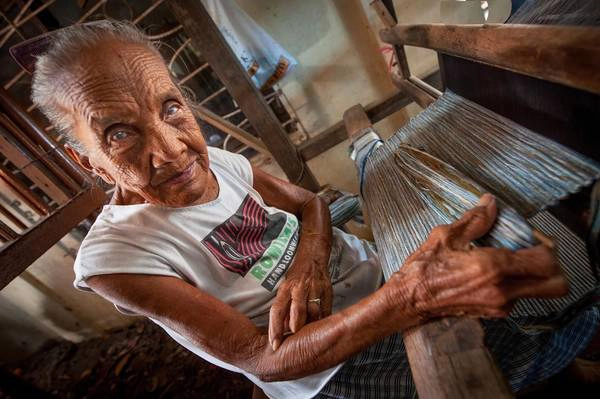 Một người phụ nữ đang làm việc trên khung cửi dệt bằng gỗ của mình ở vùng nông thôn của Bhutan.