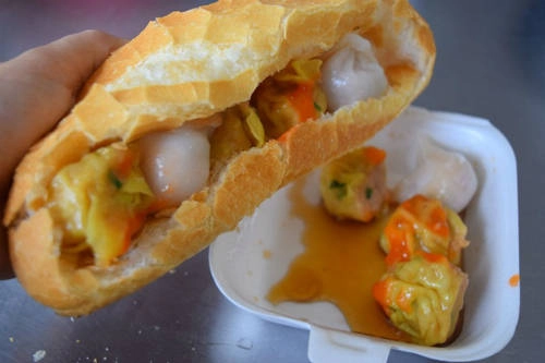 Bánh mì xíu mại khô: Trên đường Nguyễn Thị Minh Khai có một xe xíu mại há cảo nhỏ nhưng luôn nườm nượp khách suốt gần 40 năm qua. Khác với món xíu mại nước thường thấy, viên xíu mại khô được bọc trong vỏ bột hoành thánh, bỏ vào ruột bánh mỳ cùng nước tương và tương ớt. Được làm theo công thức gia truyền nên xíu mại khô ở đây có vị ngon riêng biệt, nhân đậm đà và bán ngay khi vừa hấp xong. Giá một ổ bánh mì xíu mại khô giá 17.000-20.000 đồng, tùy lượng nhân. Ảnh: Má Lúm.