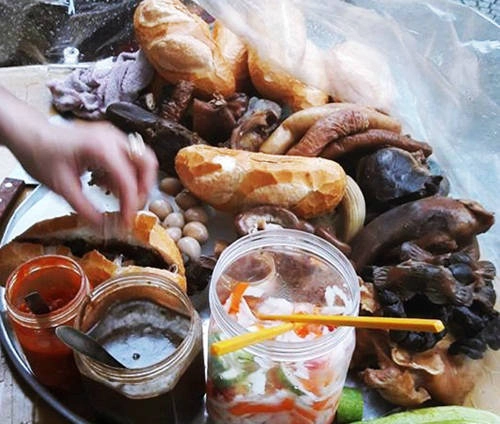 Bánh mì phá lấu: Nếu là bánh mì ăn kèm với món phá lấu nước thì được bán ở rất nhiều nơi. Nhưng bánh mì có nhân phá lấu khô ở trong thì có một nơi, nổi tiếng từ những năm 1970 đến nay. Chiều đến, lượng khách ghé mua (chỉ bán mang về) rất đông, chủ quán nhanh tay thái lòng, tháo xiên que, làm nên ổ bánh mì độc đáo. Có phá lấu heo gồm gan, lưỡi, thịt đầu, trứng cút phá lấu, phá lấu lòng vịt gồm ruột vịt, mề vịt… ăn kèm với một loại tương đen và tương ớt gia truyền, làm nên vị ngon của món ăn có từ năm 1970. Món được bán ở vỉa hè Pasteur giao với Lê Lợi, một ổ bánh mì phá lấu có giá 30.000 đồng. Ảnh: Má Lúm.