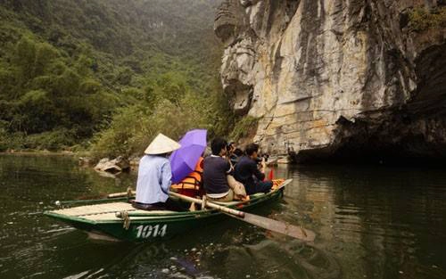 Du khách trải nghiệm du thuyền qua các hang động ở Tràng An.