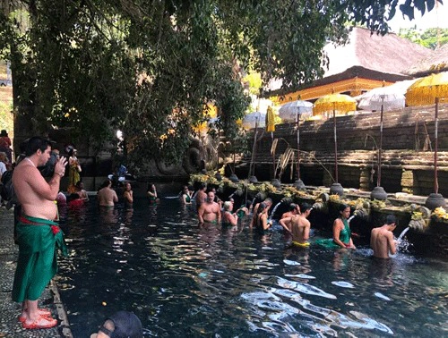 Du khách tắm rửa để tẩy trần tại dòng nước thiêng ở đền suối thiêng Tampak Siring Holy Water Spring.