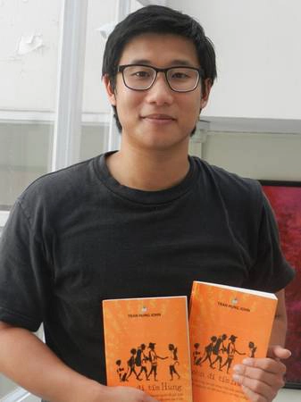 Hùng John cùng cuốn sách mà cậu xuất bản.