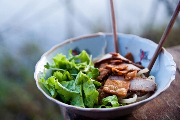 Hãy dừng chân tại một quán ven đường, gọi bát cao lầu từng được báo nước ngoài hết lời ca ngợi. Đây là đặc sản của phố Hội có từ thế kỷ 17. Một tô có chút mì cắt vừa ăn, thịt xíu, bì heo chiên giòn, và nhiều rau thơm ăn kèm. Bên cạnh cao lầu còn có bánh mì Phượng, cơm gà bà Buội, bún thịt xiên, bánh xèo giếng Bá Lễ... Ảnh: Guardian.