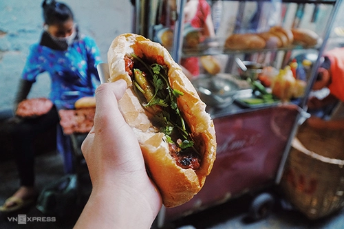 Bánh mì thịt nướng Nguyễn Trãi  Xe bánh mì nằm trong con hẻm nhỏ trên đường Nguyễn Trãi (quận 1) từng được tạp chí du lịch Mỹ Condé Nast Traveler nhắc tới trong danh sách 12 món ăn đường phố ngon nhất thế giới. Hàng chỉ bán duy nhất một loại nhân là thịt nướng, với loại sốt đặc biệt thay vì tương như ở nơi khác. Thịt nướng bán ở đây là viên thịt heo băm nhuyễn trộn gia vị kèm nước sốt theo công thức riêng của chủ rồi đem nướng trên vỉ bếp than ngay tại chỗ. Bếp nướng thịt tỏa mùi thơm quyến rũ cũng chính là đặc điểm để thực khách tìm ra vị trí xe bánh mì trong hẻm nhỏ.  Hàng này mở cửa từ 16h đến 21h và luôn đông nghẹt khách. Giá mỗi ổ là 20.000 đồng gồm 5 viên thịt, nước sốt và đồ chua.