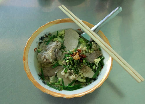 Sợi mì khô ráo nước và dẻo sau đó sẽ để vào tô, thêm sườn non, tóp mỡ và chan nước dùng rồi bưng ra phục vụ khách. Quán bán 6-13h và 16h-21h, giá một tô đầy đủ là 50.000 đồng. Ảnh: Khánh Bằng.