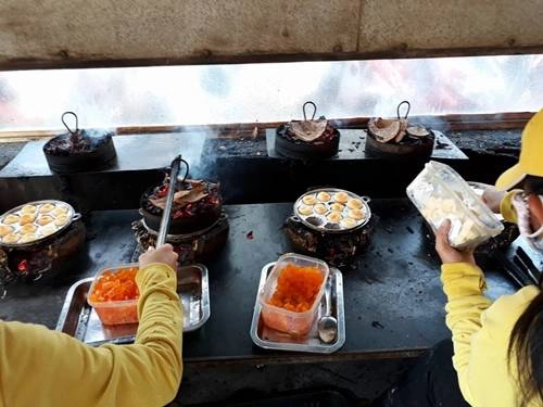 Bánh sắp chín thì bỏ viên trứng muối vào, chỉ 5 phút là đã có một mẻ bánh mới ra lò. Giá một hộp là 25.000 đồng, nếu thêm chà bông (ruốc) là 30.000 đồng. Ảnh: Dung Rùa.