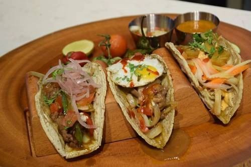 Bánh Taco Taco là món ăn truyền thống của người Mexcio, vỏ bánh được làm từ bột ngô, nướng giòn, nhân bên trong đa dạng và cầu kỳ đến từng loại gia vị. Nhân bánh Taco ở phố đi bộ có kiểu truyền thống như nhân thịt heo Mexico, bắp răng, sốt ớt; nhân bò Fajita, ớt chuông và phô mai. Kiểu nhân biến tấu có bò BBQ, kim chi, trứng cút hoặc thịt gà cùng bưởi… Bạn có thể thưởng thức ở quán do chính tay Michael Bảo Huỳnh - Giám khảo Siêu đầu bếp 2012 làm. Giá một phần khoảng 30.000 - 40.000 đồng. Ảnh: Má Lúm.