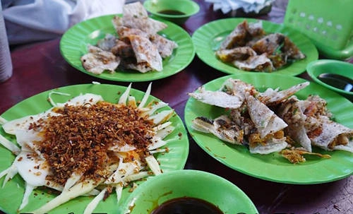 Bánh tráng kẹp: Đây là một biến tấu của món bánh tráng nướng, nhưng lớp nhân phong phú hơn và thứ nước chấm riêng biệt của chủ quán làm nên sức hút khiến quán bánh tráng kẹp vỉa hè luôn nườm nượp khách. Các loại bánh tráng kẹp đồng giá 10.000 đồng một đĩa như: bánh kẹp pate, bánh kẹp bò khô, bánh kẹp mực, bánh kẹp ốp-la& Quán nằm ở ngã tư Nguyễn Thị Minh Khai và Tô Hiến Thành, bán từ 3h chiều trở đi. Ảnh: HiQuyNhon Bánh tráng kẹp: Đây là một biến tấu của món bánh tráng nướng, nhưng lớp nhân phong phú hơn và thứ nước chấm riêng biệt của chủ quán làm nên sức hút khiến quán bánh tráng kẹp vỉa hè luôn nườm nượp khách. Các loại bánh tráng kẹp đồng giá 10.000 đồng một đĩa như: bánh kẹp pate, bánh kẹp bò khô, bánh kẹp mực, bánh kẹp ốp-la& Quán nằm ở ngã tư Nguyễn Thị Minh Khai và Tô Hiến Thành, bán từ 3h chiều trở đi. Ảnh: HiQuyNhon