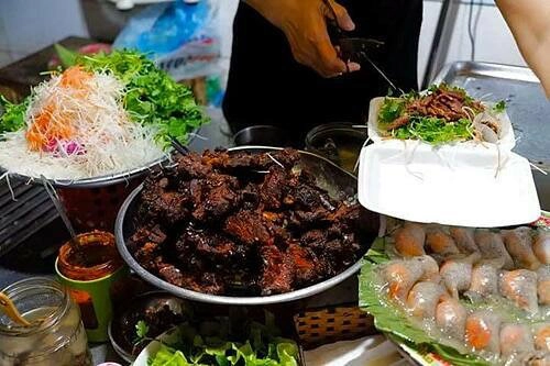 Nộm bò khô  Quán nộm bò khô là địa chỉ ăn uống yêu thích của nhiều thực khách trẻ. Bò khô ở đây được ướp với ớt, sả, gừng và bột canh, đường, sau đó sấy cả miếng lớn để giữ độ ngọt, mềm của thịt. Khi ăn, thịt sẽ được cắt thành từng miếng nhỏ chừng 2 đốt ngón tay, trộn cùng đu đủ xanh, cà rốt thái sợi và lạc rang. Sợi rau thấm đẫm trong nước sốt chua ngọt, ăn kèm với bò khô mặn ngọt và lạc rang mang đến hương vị hài hòa không ngán. Mỗi bát nộm bò khô có giá 30.000 đồng.  Ngoài nộm, bạn có thể thưởng thức thêm bánh bột lọc nhân tôm thịt. Bánh mới luôn được bán hết trong ngày nên mùi thơm, không bị dai, cứng. Ảnh: Lan Hương.