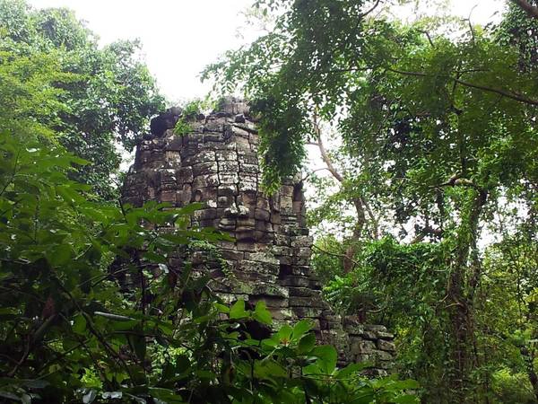 Khuôn mặt khổng lồ tạc vào đá nhìn ra bốn hướng trên đỉnh của một tòa tháp Khuôn mặt khổng lồ tạc vào đá nhìn ra bốn hướng trên đỉnh của một tòa tháp