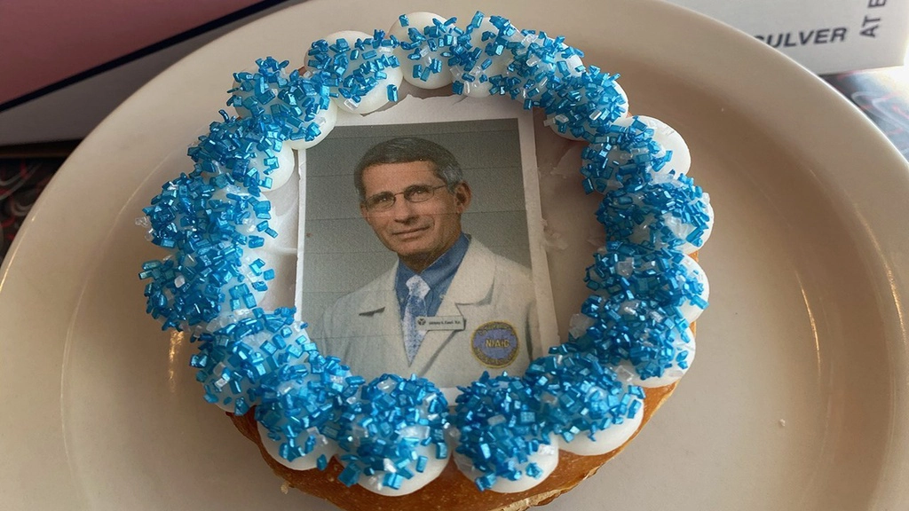 Tại Mỹ, một tiệm donut đã sáng tạo món bánh in hình vị bác sĩ nổi tiếng trong chiến dịch chống Covid-19, Anthony Fauci. Hình ảnh bác sĩ Fauci được in lên một tờ giấy ăn được, sau đó đặt lên trên lớp kem bơ của bánh. Giá mỗi chiếc “bánh bác sĩ Fauci” là 2,11 USD (49.000 đồng).