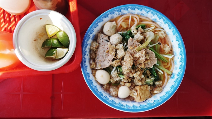 Bún đỏ  Bún đỏ là món ăn bình dân của người Đắk Lắk. Ở trung tâm thành phố Buôn Ma Thuột, từ gánh hàng vỉa hè cho đến quán ăn sang trọng, thực khách không khó để tìm địa chỉ để thưởng thức món ăn này. Nguyên liệu món ăn đơn giản gồm bún sợi lớn, chả viên, trứng cút luộc và rau cải. Nhiều nơi còn cho thêm tóp mỡ để tăng mùi vị.  Thông thường, người nấu sẽ dùng một nồi nước pha hạt điều rồi trụng bún bên trong, nhờ vậy mà sợi bún có màu đỏ đặc trưng. Món ăn thường được bán từ xế chiều đến tối muộn, giá trung bình từ 20.000 đồng. Đường Phan Đình Giót, Lê Hồng Phong hay Phan Bội Châu có nhiều quán bán món này.