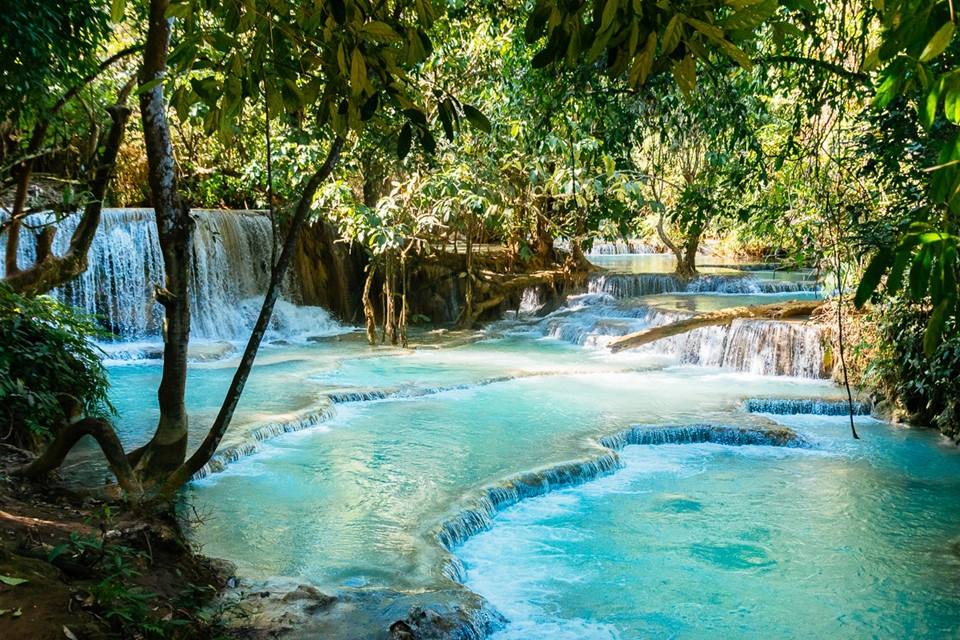 Đầm Blue Lagoon: Đầm xanh biếc nằm cách thị trấn Vang Vieng khoảng 7 km nên du khách dễ dàng đến đây bằng xe tuk tuk hoặc xe đạp, phương tiện công cộng. Quần thể thiên nhiên này gồm các đầm phá khá sâu với dòng nước xanh biếc tự nhiên. Du khách đến đây sẽ hòa mình vào không gian thiên nhiên đẹp như tuyệt tác với thác nước nhỏ nhiều tầng nằm giữa đồi núi xanh ngắt. Ảnh: SundownTraveler. Đầm Blue Lagoon: Đầm xanh biếc nằm cách thị trấn Vang Vieng khoảng 7 km nên du khách dễ dàng đến đây bằng xe tuk tuk hoặc xe đạp, phương tiện công cộng. Quần thể thiên nhiên này gồm các đầm phá khá sâu với dòng nước xanh biếc tự nhiên. Du khách đến đây sẽ hòa mình vào không gian thiên nhiên đẹp như tuyệt tác với thác nước nhỏ nhiều tầng nằm giữa đồi núi xanh ngắt. Ảnh: SundownTraveler.