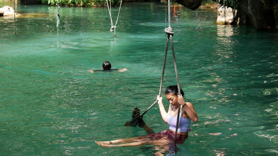 Địa hình độc đáo của đầm Blue Lagoon khiến dịch vụ các trò chơi mạo hiểm phát triển mạnh. Người Lào và du khách tham quan thường trải nghiệm ngồi ghế treo đung đưa, nhảy nhào lộn từ trên cao hoặc đu dây zip line đầy phiêu lưu. Trước khi đến đầm xanh này, lữ khách còn có thể tham quan quần thể động Poukham mênh mông xung quanh với sông núi hài hòa. Ảnh: CNN. Địa hình độc đáo của đầm Blue Lagoon khiến dịch vụ các trò chơi mạo hiểm phát triển mạnh. Người Lào và du khách tham quan thường trải nghiệm ngồi ghế treo đung đưa, nhảy nhào lộn từ trên cao hoặc đu dây zip line đầy phiêu lưu. Trước khi đến đầm xanh này, lữ khách còn có thể tham quan quần thể động Poukham mênh mông xung quanh với sông núi hài hòa. Ảnh: CNN.