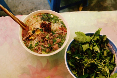 Bún ốc Hàng Chai: Bún ăn theo kiểu chan nước dùng nóng vào bát, có thêm vài cọng hành lá, mấy miếng cà chua… kèm rau sống thơm ngọt lại mát. Nước dùng trong vắt, có phần chua hơn so với bún ốc khác nhưng vẫn rất thanh, đậm đà và vừa miệng, tạo nên hương vị quyến rũ khó cưỡng lại. Một tô bún ốc ở phố Hàng Chai được bán 30.000 đồng. Ảnh: Phong Vinh.
