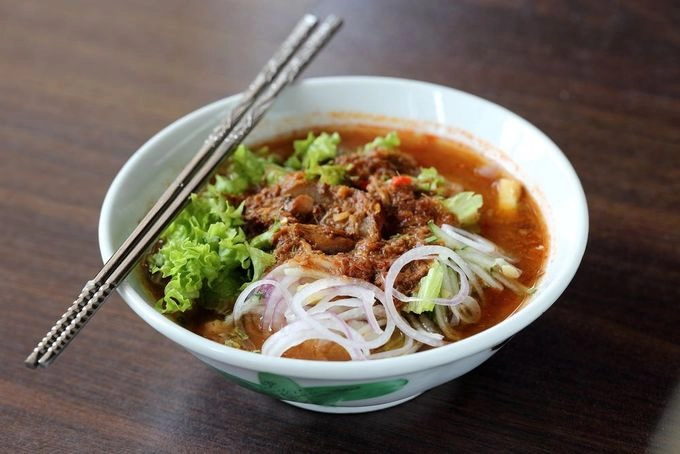 Assam laksa  Đây là một loại mì gạo với nước dùng me chua, cá thu và rau sống. Tuy nhiên, assam laksa đặc biệt đậm đà và cay nên có thể không hợp với khẩu vị nhiều thực khách.  Giá khoảng 4 RM (22.000 đồng) mỗi bát. Ở đảo Penang, du khách có thể thưởng thức mì ở nhà hàng Penang Air Itam Laksa, George Town. Ở thủ đô Kuala Lumpur, nhà hàng gợi ý là Mark's Assam Laksa. Ảnh: Shutterstock/Grass Life Good.