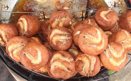 Bánh cống: Tới Sóc Trăng, du khách dễ gặp những xe bán bánh cống vàng rộm ở dọc đường hay trong các khu chợ. Lý giải tên gọi bánh cống, khuôn làm bánh bằng nhôm hình tròn, trên có tay cầm để khi đổ bánh dễ dàng cho việc vớt, người Sóc Trăng gọi là cống. Bánh cống ngon nhất là ở chính nơi được cho là nguồn gốc của nó - ngã ba đường vào chợ Đại Tâm, huyện Mỹ Xuyên (cách TP Sóc Trăng khoảng 8 km). Mỗi chiếc bánh cống có giá 8.000 đồng, ăn kèm rau sống và nước mắm chua ngọt, tạo nên vị đậm đà giòn rụm cùng vị thanh mát của rau. Ảnh: Ngọc Quí. Bánh cống: Tới Sóc Trăng, du khách dễ gặp những xe bán bánh cống vàng rộm ở dọc đường hay trong các khu chợ. Lý giải tên gọi bánh cống, khuôn làm bánh bằng nhôm hình tròn, trên có tay cầm để khi đổ bánh dễ dàng cho việc vớt, người Sóc Trăng gọi là cống. Bánh cống ngon nhất là ở chính nơi được cho là nguồn gốc của nó - ngã ba đường vào chợ Đại Tâm, huyện Mỹ Xuyên (cách TP Sóc Trăng khoảng 8 km). Mỗi chiếc bánh cống có giá 8.000 đồng, ăn kèm rau sống và nước mắm chua ngọt, tạo nên vị đậm đà giòn rụm cùng vị thanh mát của rau. Ảnh: Ngọc Quí.