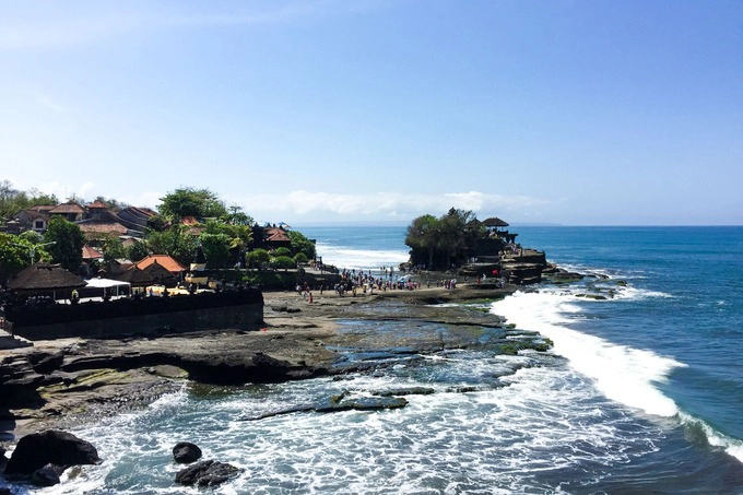 Tanah Lot là ngôi đền được xây dựng trên một khối đá khổng lồ bên bờ biển. Truyền thuyết kể rằng ngôi đền được xây dựng từ năm 1546 bởi một tu sĩ người Ấn Độ đến Bali để truyền bá đạo Hindu. Người dân Bali tin rằng, ngôi đền được bảo vệ bởi những con rắn thần, hàng đêm chúng sẽ bò lên để nhận vật cúng dường. Tanah Lot cũng là một trong những điểm ngắm hoàng hôn đẹp nhất trên đảo Bali. Ảnh: Khương Nha.