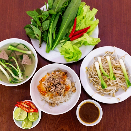 Phở khô Gia Lai Sợi phở khô nhỏ như hủ tiếu, săn và hơi dai. Món ăn thường được phục vụ hai tô: một tô đựng bánh phở kèm thịt băm và một tô nước lèo trong, vị thanh ngọt. Đầu bếp thường hầm xương lợn và bò để ra nước có vị đậm đà này. Khách có thể lựa chọn đồ ăn kèm là thịt gà, bò hoặc bò viên. Mỗi suất ăn dao động từ 30.000 đồng. Các nhà hàng thường phục vụ thêm rau, giá. Địa chỉ gợi ý: Quán phở khô Hồng là địa chỉ bạn không thể bỏ qua. Ảnh: Mr True. Phở khô Gia Lai Sợi phở khô nhỏ như hủ tiếu, săn và hơi dai. Món ăn thường được phục vụ hai tô: một tô đựng bánh phở kèm thịt băm và một tô nước lèo trong, vị thanh ngọt. Đầu bếp thường hầm xương lợn và bò để ra nước có vị đậm đà này. Khách có thể lựa chọn đồ ăn kèm là thịt gà, bò hoặc bò viên. Mỗi suất ăn dao động từ 30.000 đồng. Các nhà hàng thường phục vụ thêm rau, giá. Địa chỉ gợi ý: Quán phở khô Hồng là địa chỉ bạn không thể bỏ qua. Ảnh: Mr True.