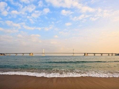 <strong>Ngắm biển Gwangalli: </strong> Bạn có thể đến bãi biển này bằng tàu điện ngầm. So với Haeundae, Gwangalli không có nhiều khách sạn hạng sang hay đông đúc người trên bãi biển. Nơi đây khá yên bình và có không khí trong lành. Các nhà hàng, quán cà phê, bar cũng luôn sẵn sàng phục vụ du khách. Buổi tối là thời gian lý tưởng để trải nghiệm Gwangalli. Từ đây, du khách có thể hướng ánh nhìn ra cầu Gwangan với hệ thống đèn chiếu có thể tạo ra hơn 100.000 màu sắc khác nhau. <strong>Ngắm biển Gwangalli: </strong> Bạn có thể đến bãi biển này bằng tàu điện ngầm. So với Haeundae, Gwangalli không có nhiều khách sạn hạng sang hay đông đúc người trên bãi biển. Nơi đây khá yên bình và có không khí trong lành. Các nhà hàng, quán cà phê, bar cũng luôn sẵn sàng phục vụ du khách. Buổi tối là thời gian lý tưởng để trải nghiệm Gwangalli. Từ đây, du khách có thể hướng ánh nhìn ra cầu Gwangan với hệ thống đèn chiếu có thể tạo ra hơn 100.000 màu sắc khác nhau.