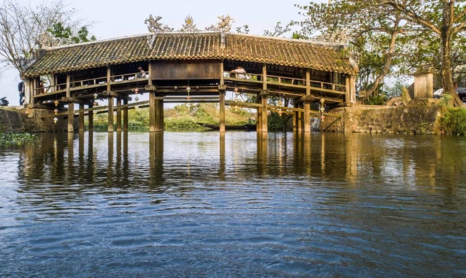 Cầu ngói Thanh Toàn  Cầu ngói Thanh Toàn nằm ở làng Thanh Thủy Chánh, xã Thủy Thanh, thị xã Hương Thủy. Công trình này làm bằng gỗ, kiến trúc theo kiểu "thượng gia, hạ kiều", tức trên nhà dưới cầu, dài hơn 18 m, rộng gần 6 m. Đây là một trong số ít cây cầu với kiểu kiến trúc này còn tồn tại đến ngày nay ở Việt Nam. Cây cầu cách trung tâm thành phố chừng 8 km. Bạn có thể đi trước để dành thời gian chiều nghỉ ngơi ở thôn Vĩ Dạ. Ảnh: Thanh Toàn.